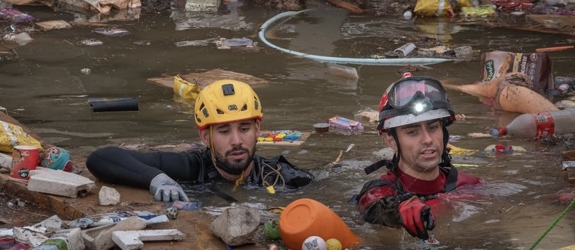 imagen de socorristas nadando entre el fango del rio desbordado